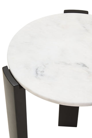 Round side table featuring a smooth white marble top with subtle gray veining, supported by sleek black acacia wood legs.