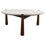 Round coffee table featuring a smooth travertine top with subtle texture and natural color variations, supported by four tapered brown mango wood legs.