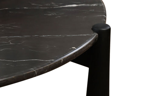 Round black marble top coffee table featuring a sleek design with white veining, complemented by sturdy mango wood legs.