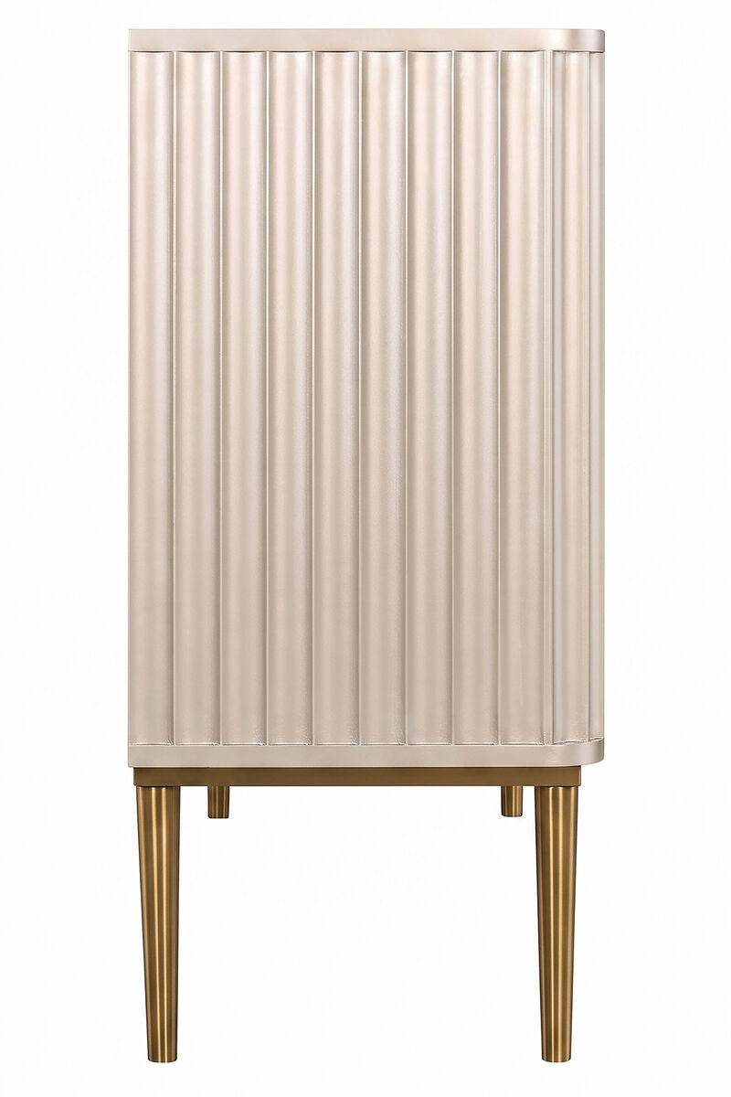 Three-door sideboard featuring a sleek, ribbed design in a soft gold finish. The cabinet is supported by elegant, tapered legs, also in gold, adding a touch of sophistication.