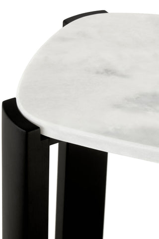 Close-up view of a console table featuring a smooth white marble top with subtle gray veining, complemented by sleek black acacia wood legs.
