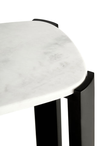 Close-up view of a console table featuring a smooth white marble top with subtle gray veining, complemented by sleek black acacia wood legs.