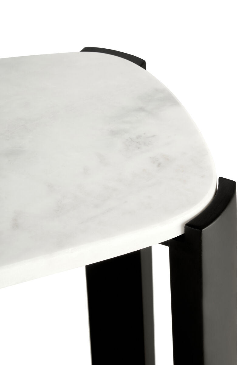 Close-up view of a console table featuring a smooth white marble top with subtle gray veining, complemented by sleek black acacia wood legs.