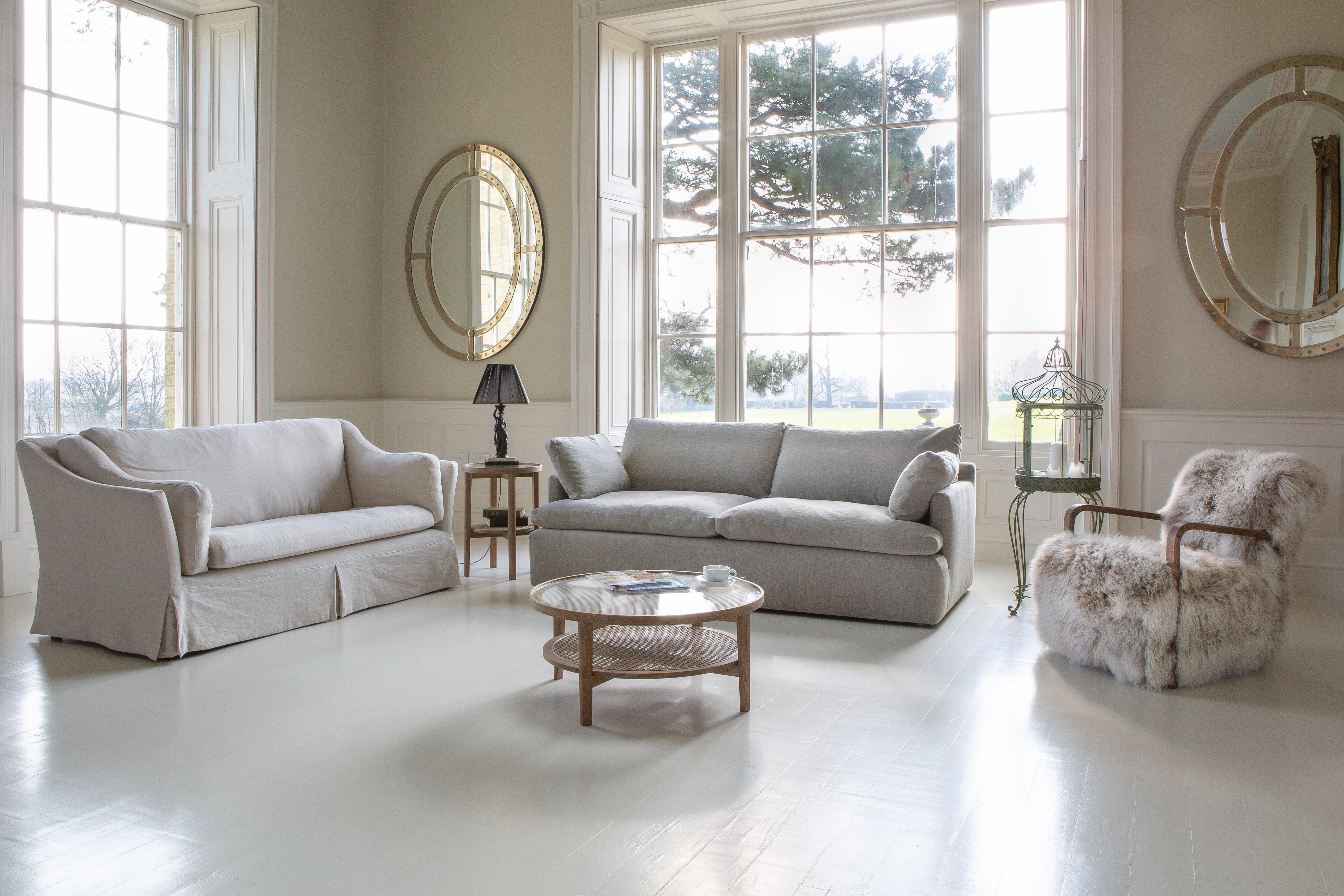 Neutral living room with two fabric sofas, fur armchair and round wooden coffee table