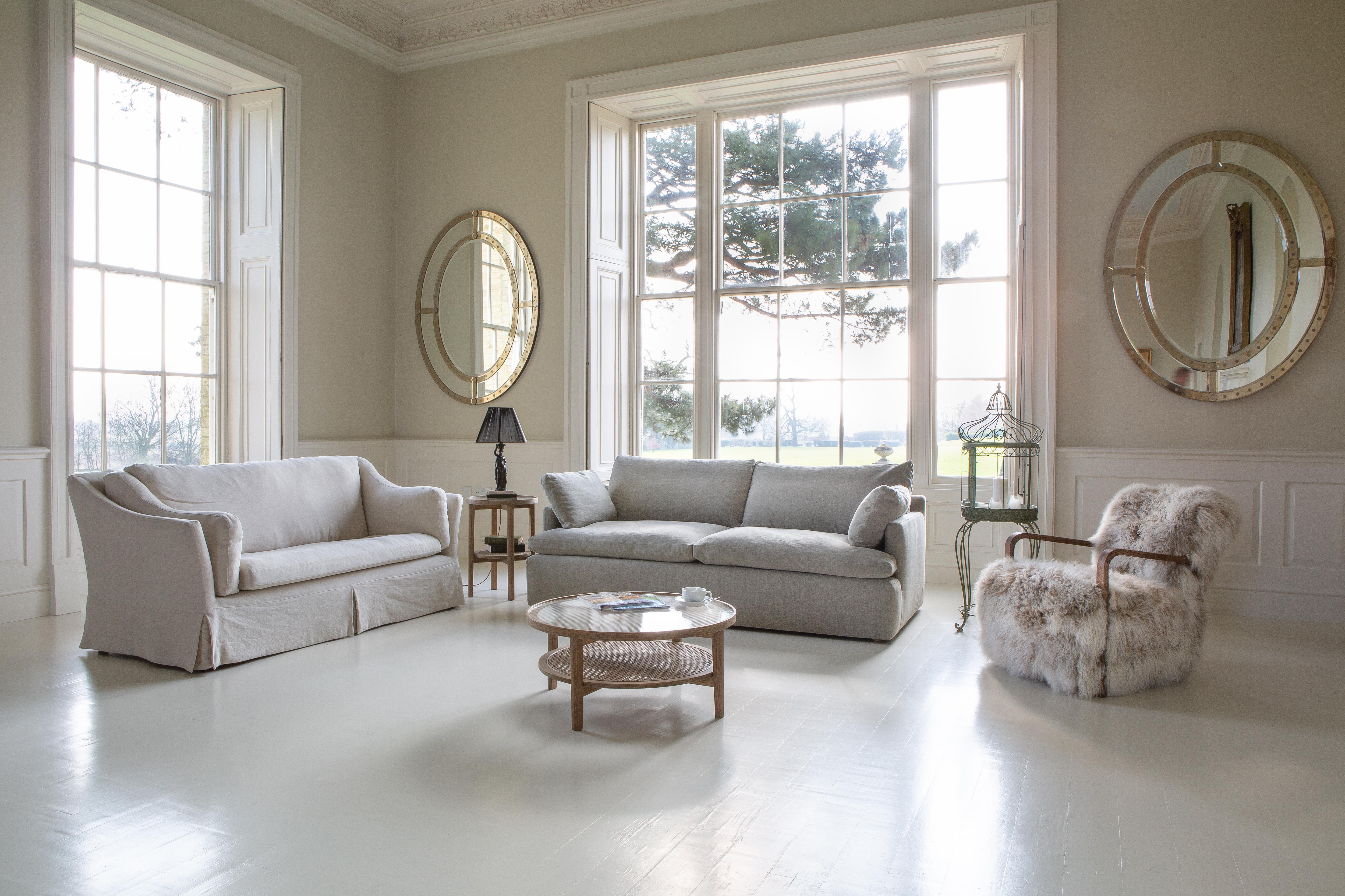 Modern living room with two neutral sofas, round coffee table and faux fur accent chair