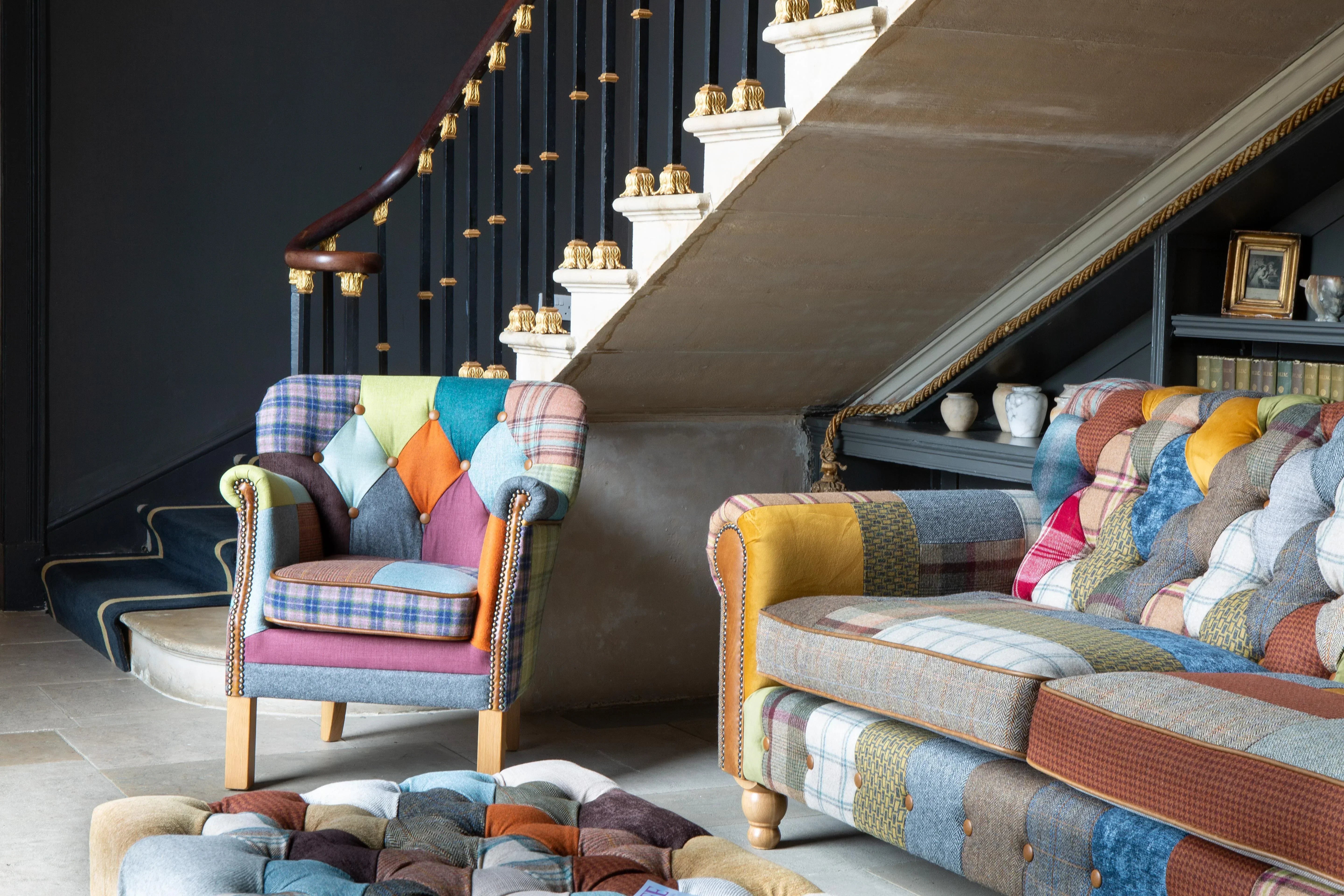 Patchwork fabric armchair and sofa with wooden legs in a staircase living room setting