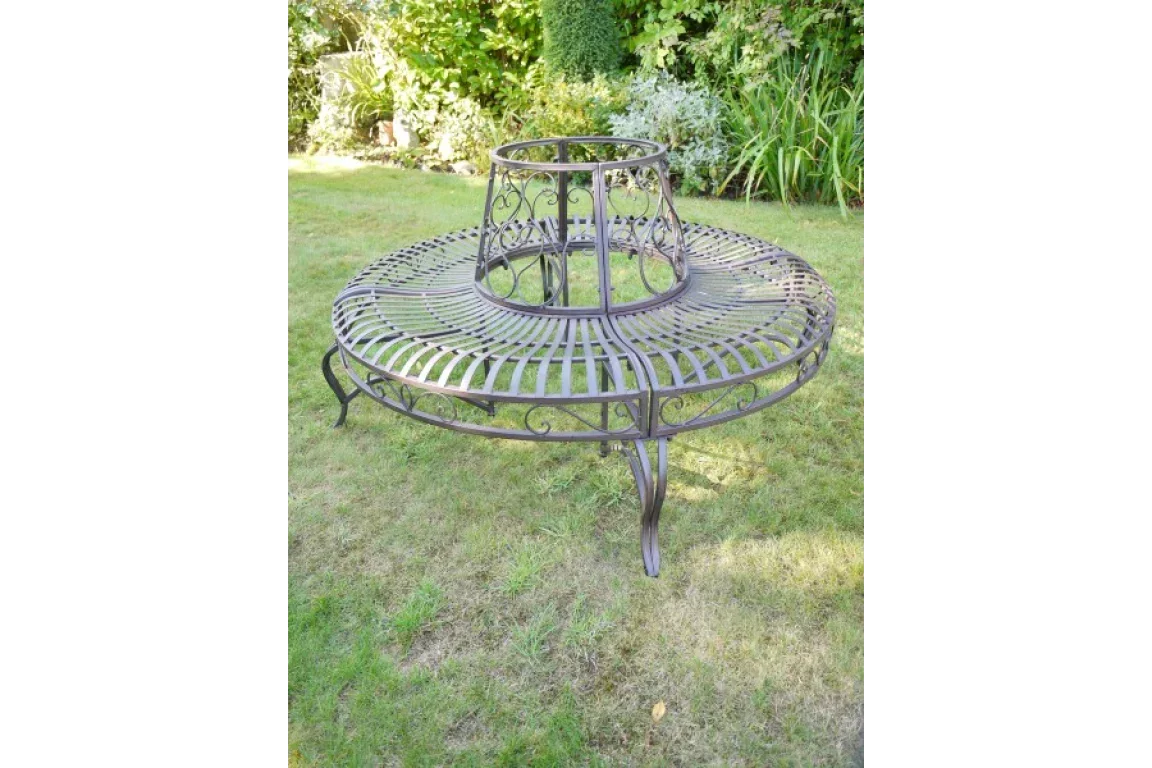 Vintage metal tree bench with ornate scrollwork design on garden lawn