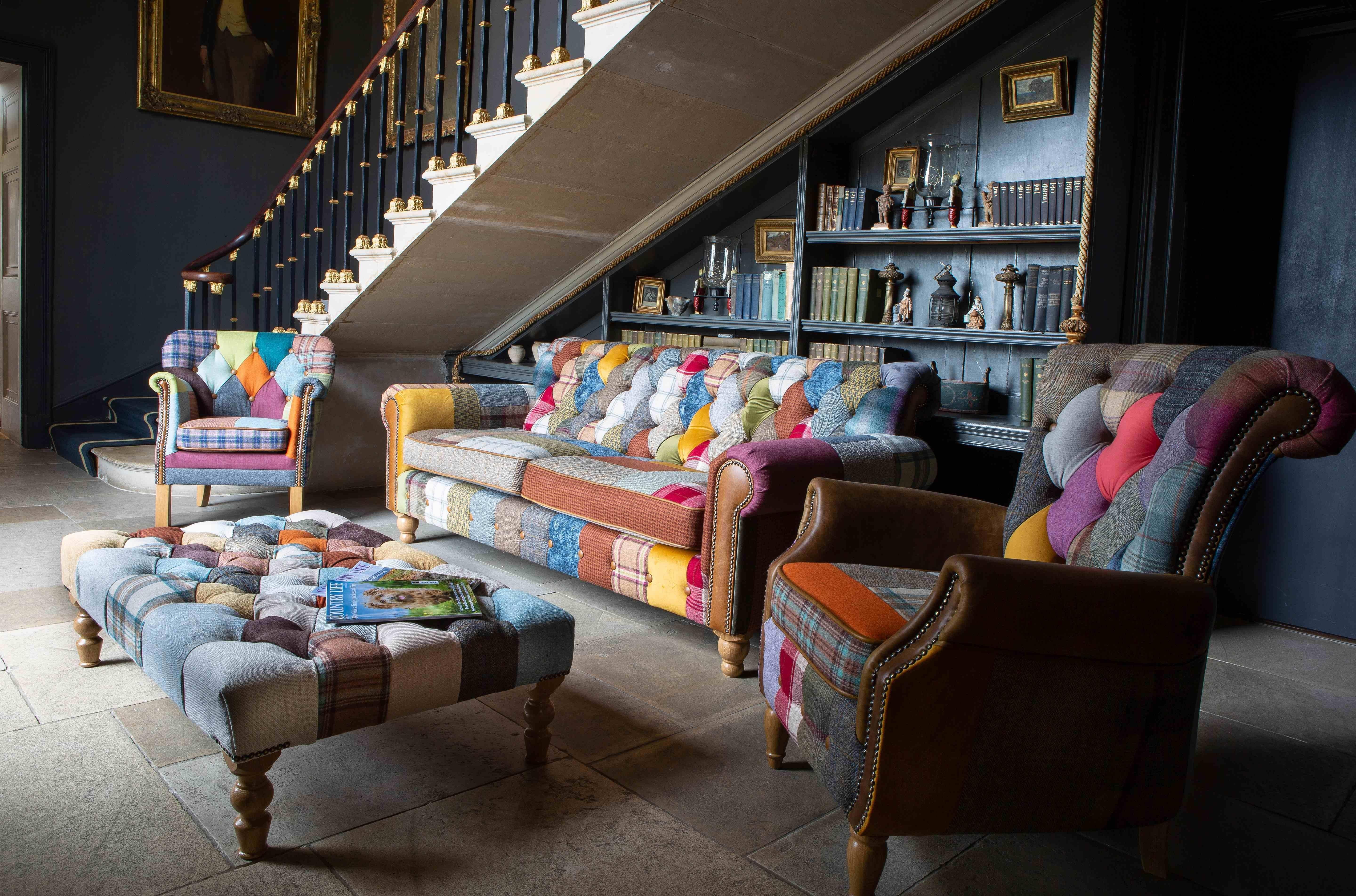 Patchwork fabric sofa set with armchairs and footstool in living room with bookshelves