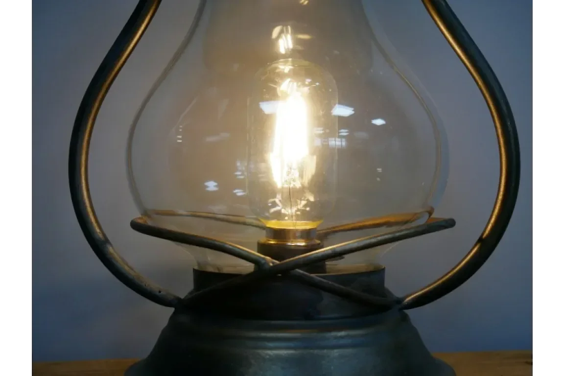 Close-up of vintage table lamp with clear glass shade and exposed light bulb