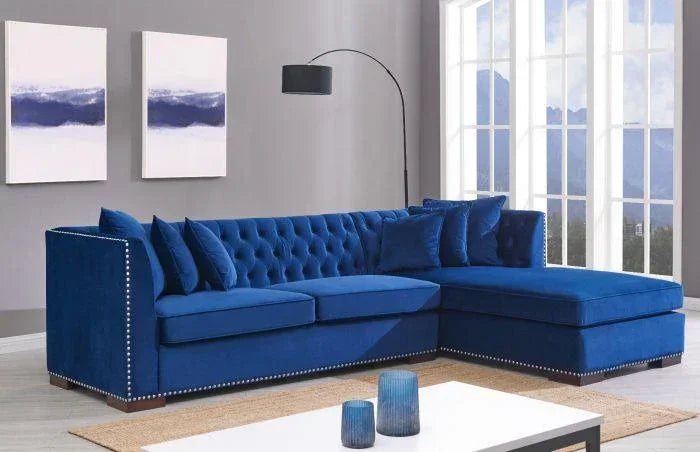 Blue velvet corner sofa with tufted back, studded trim and matching cushions in modern living room