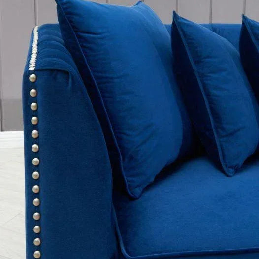 Blue velvet sofa with studded armrest and matching scatter cushions