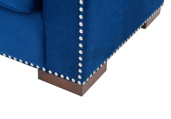 Blue velvet sofa corner with silver stud detailing and wooden feet