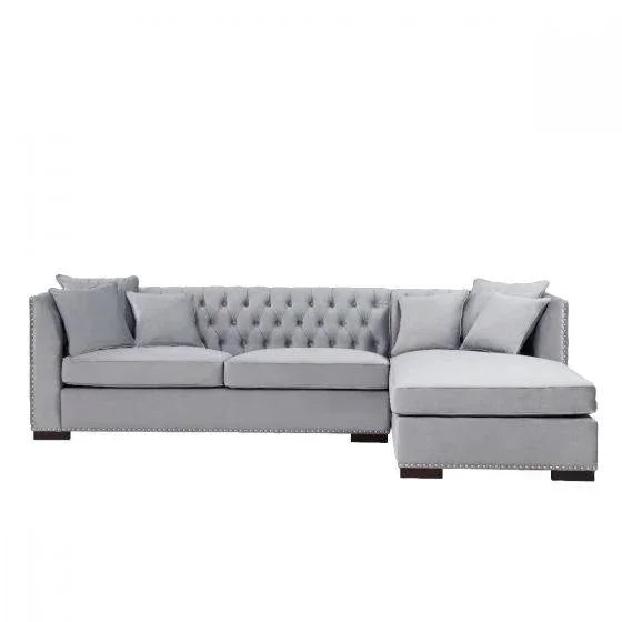Grey corner sofa with chaise, button-tufted back, studded trim, and scatter cushions