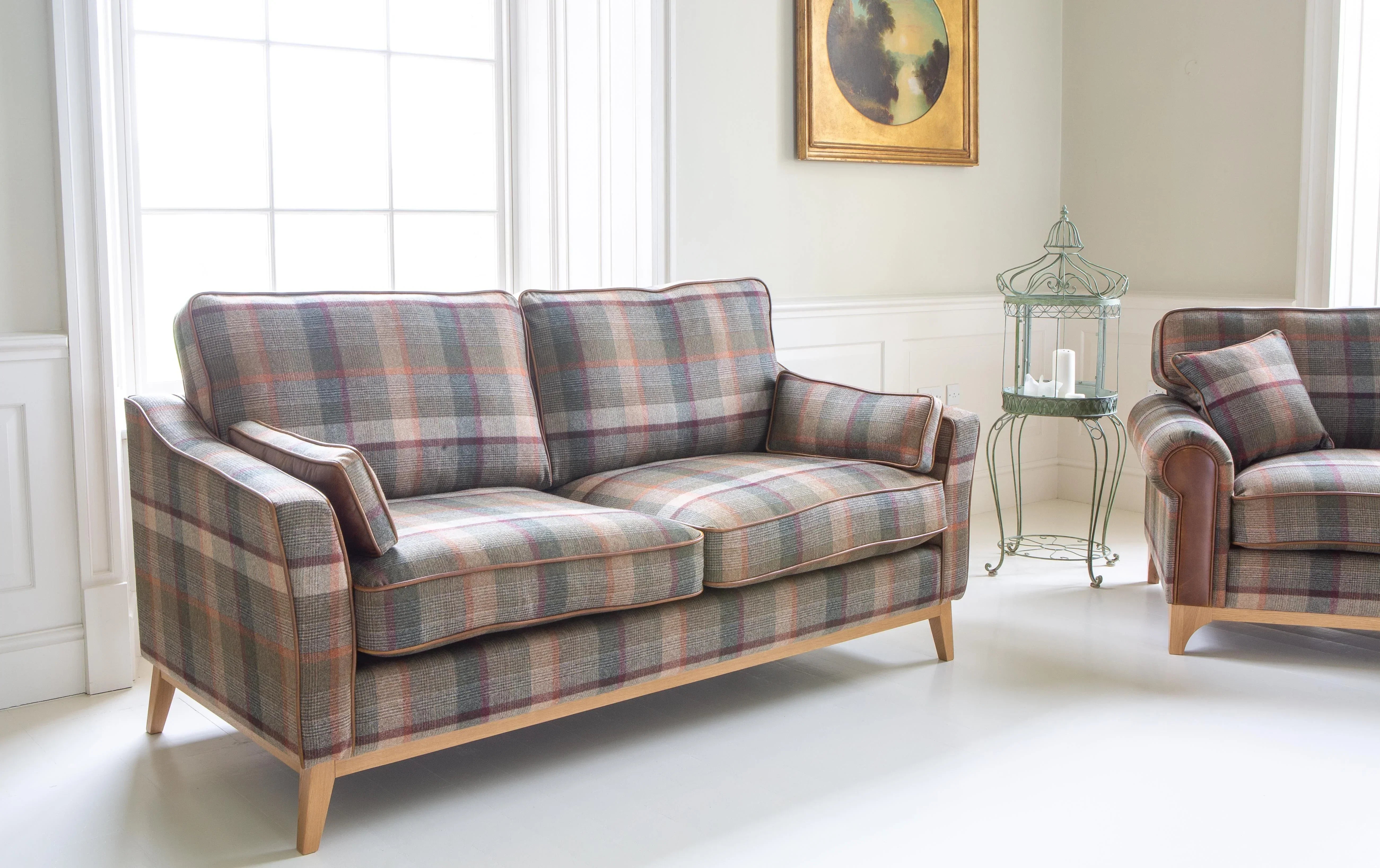 Tartan fabric sofa with wooden legs in a bright living room beside a large window