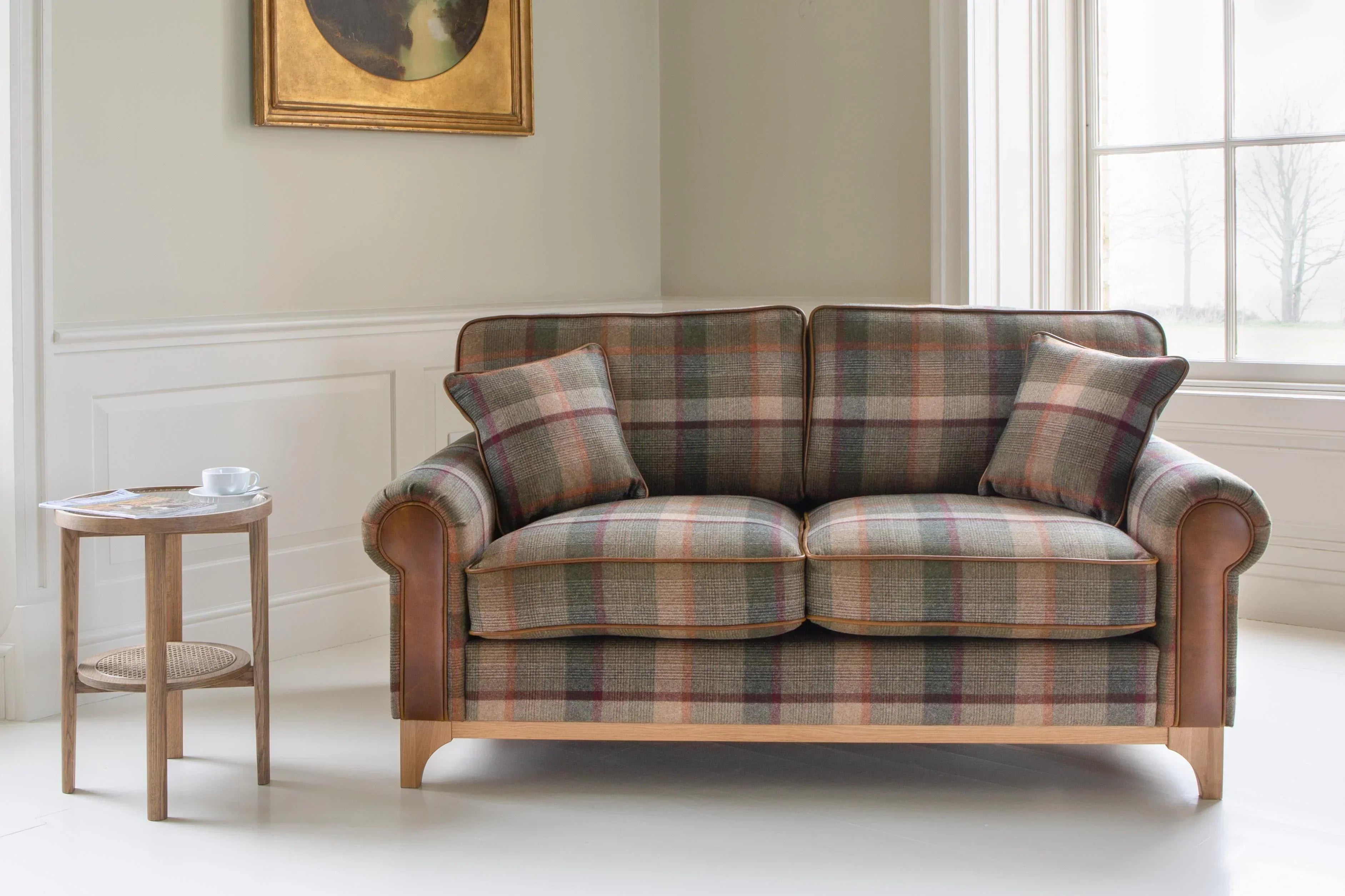 Plaid fabric sofa with wooden legs and matching cushions in a bright living room
