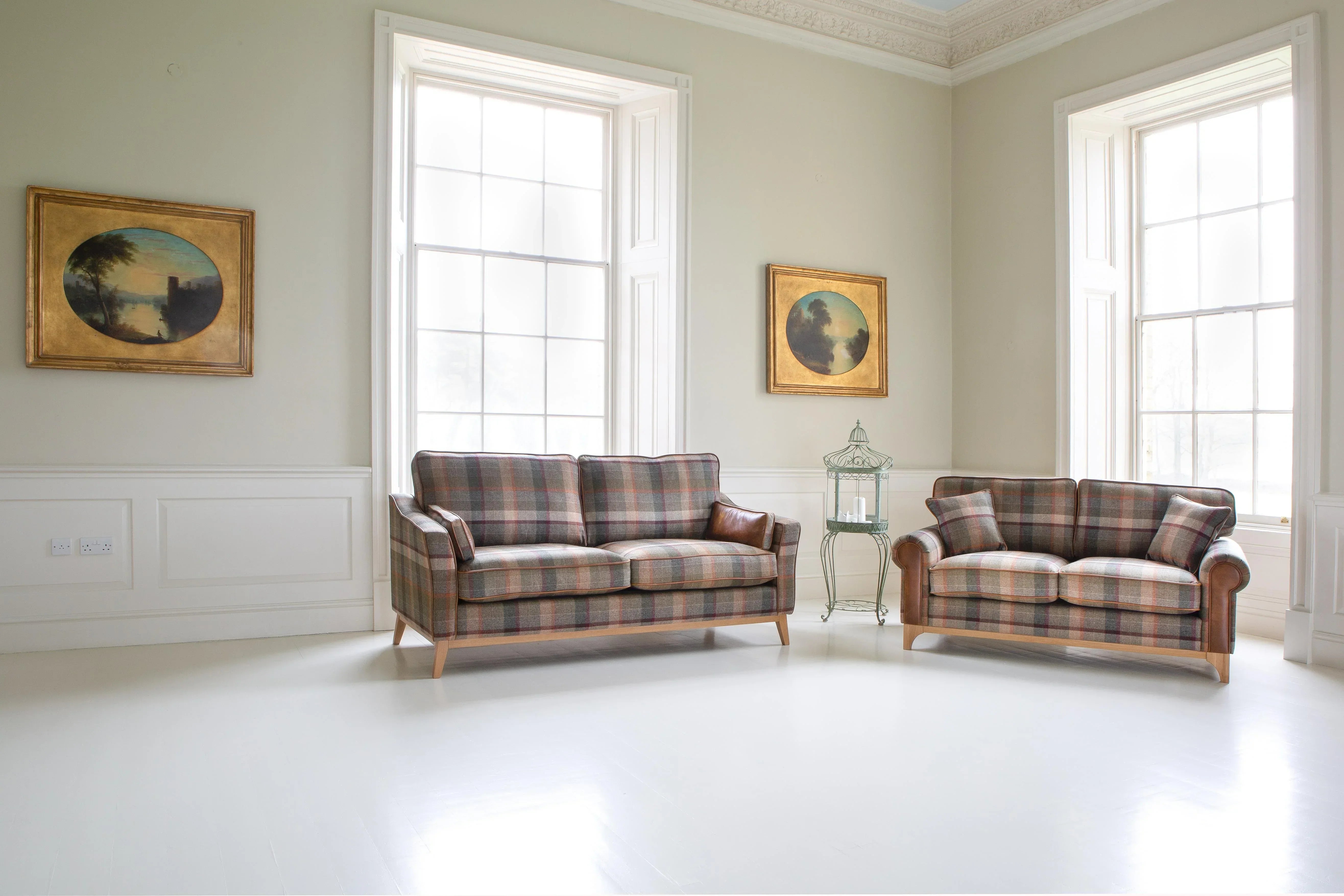 Plaid fabric sofas with wooden legs in a bright living room with large windows