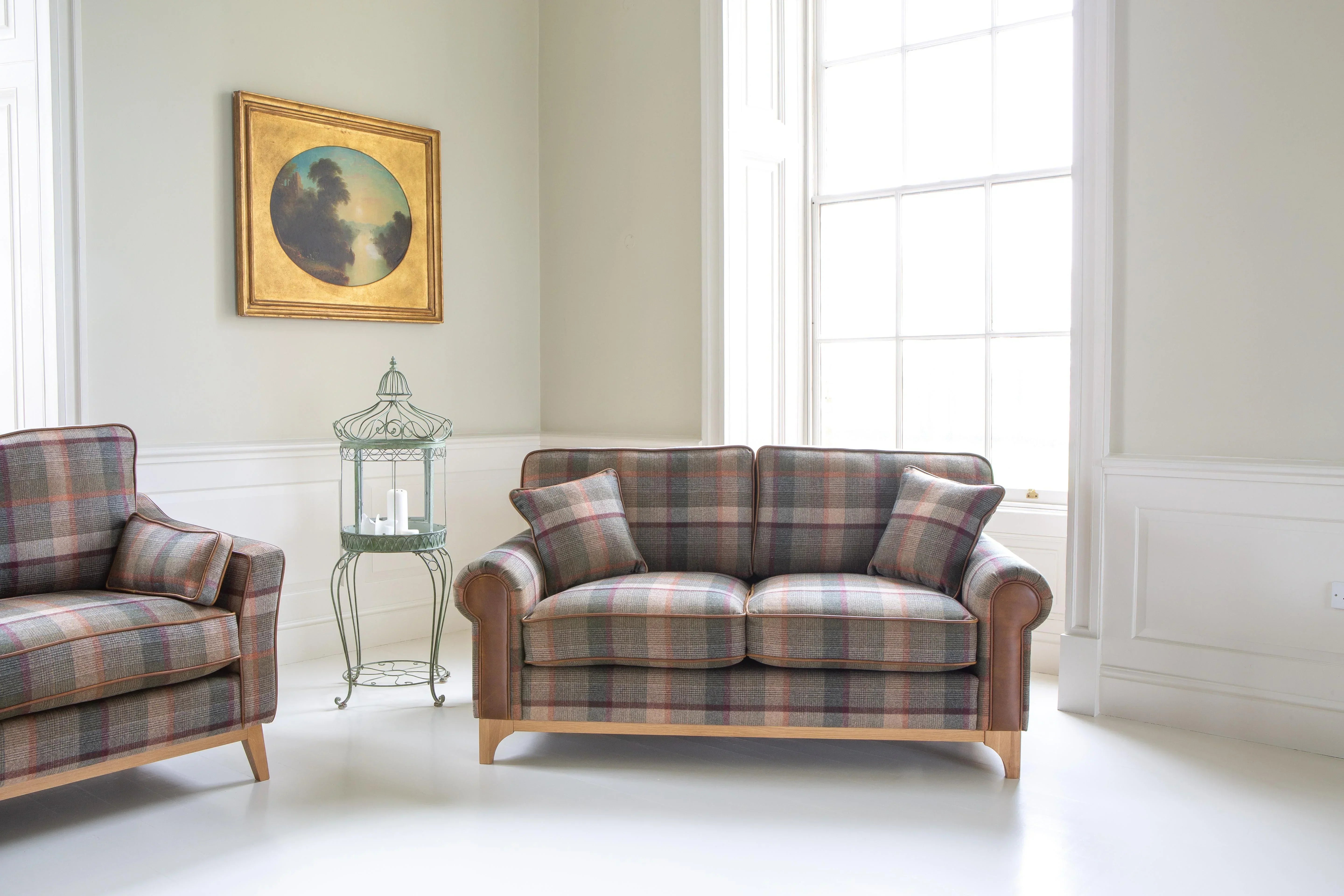 Plaid fabric sofa with matching cushions in bright living room with large window