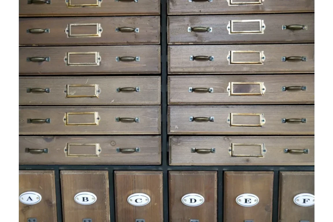 Wooden storage drawers with brass handles and labeled compartments A to F at bottom