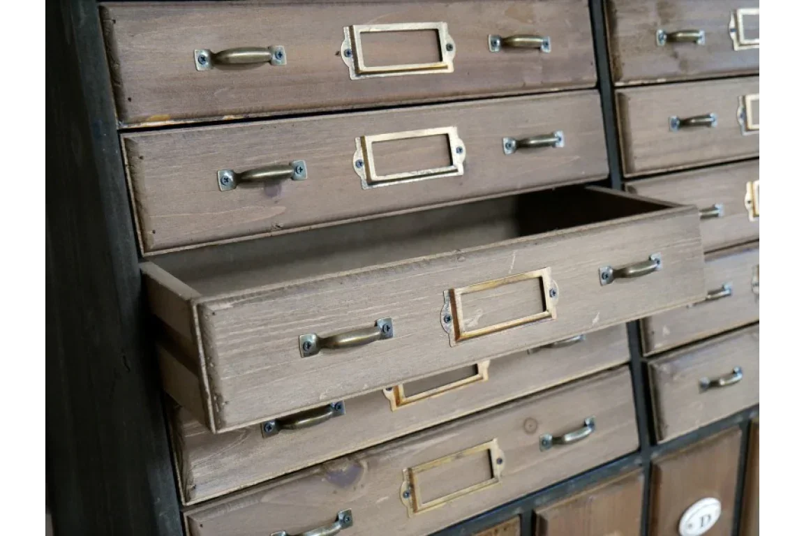Brown wooden storage drawers with brass handles and label holders, one drawer partially open