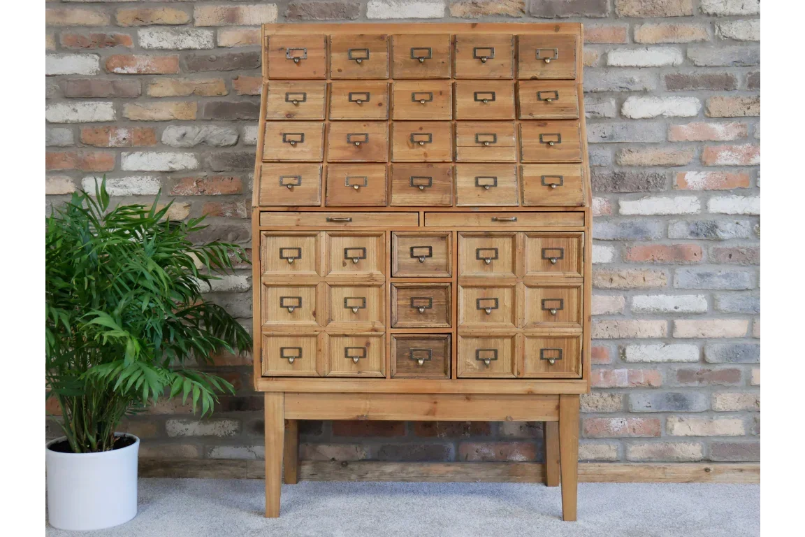 Wooden multi-drawer storage cabinet with metal handles against brick wall, indoor furniture
