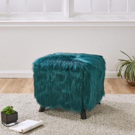 Teal faux fur ottoman with black legs on beige rug in modern living room