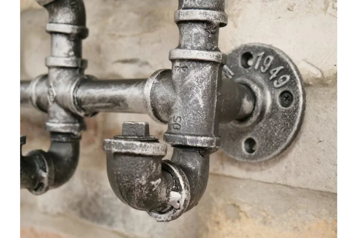 Industrial metal pipe fixture with vintage wall mounting detail