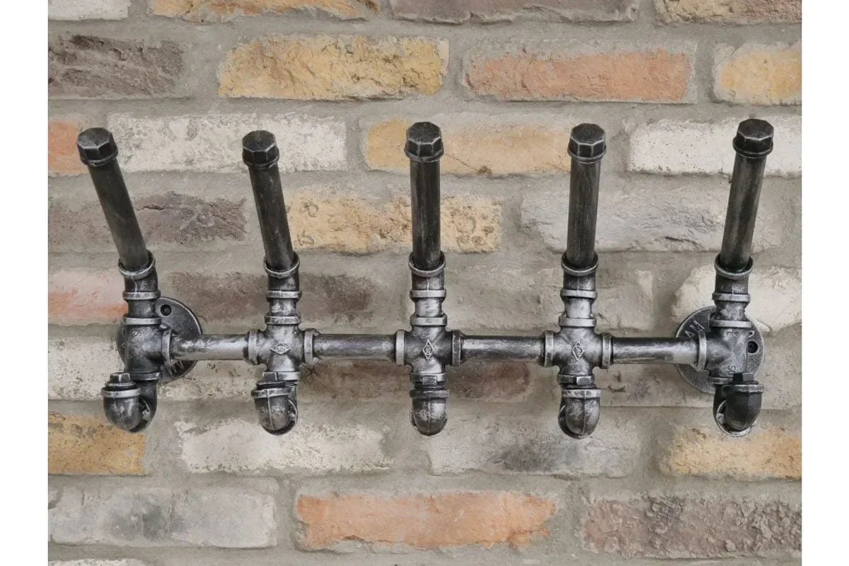 Industrial style wall mounted coat rack with metal pipe design and five hooks on brick wall