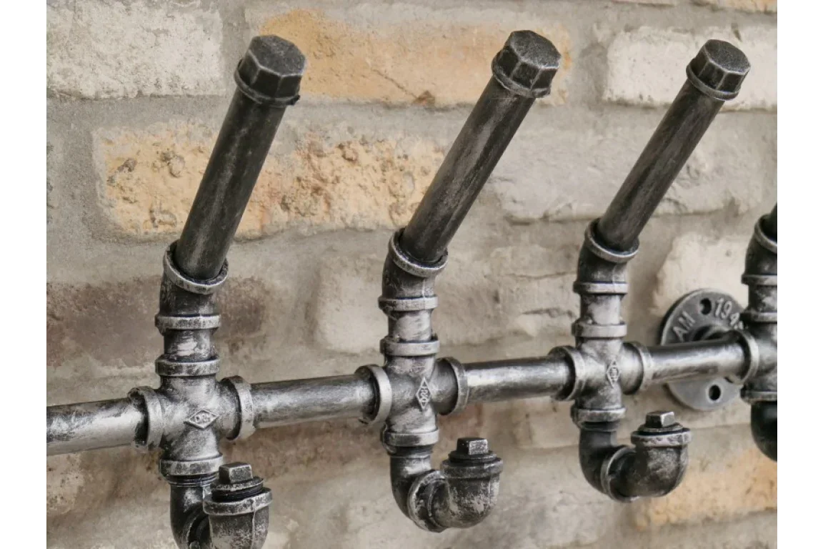 industrial pipe coat hooks on exposed brick wall