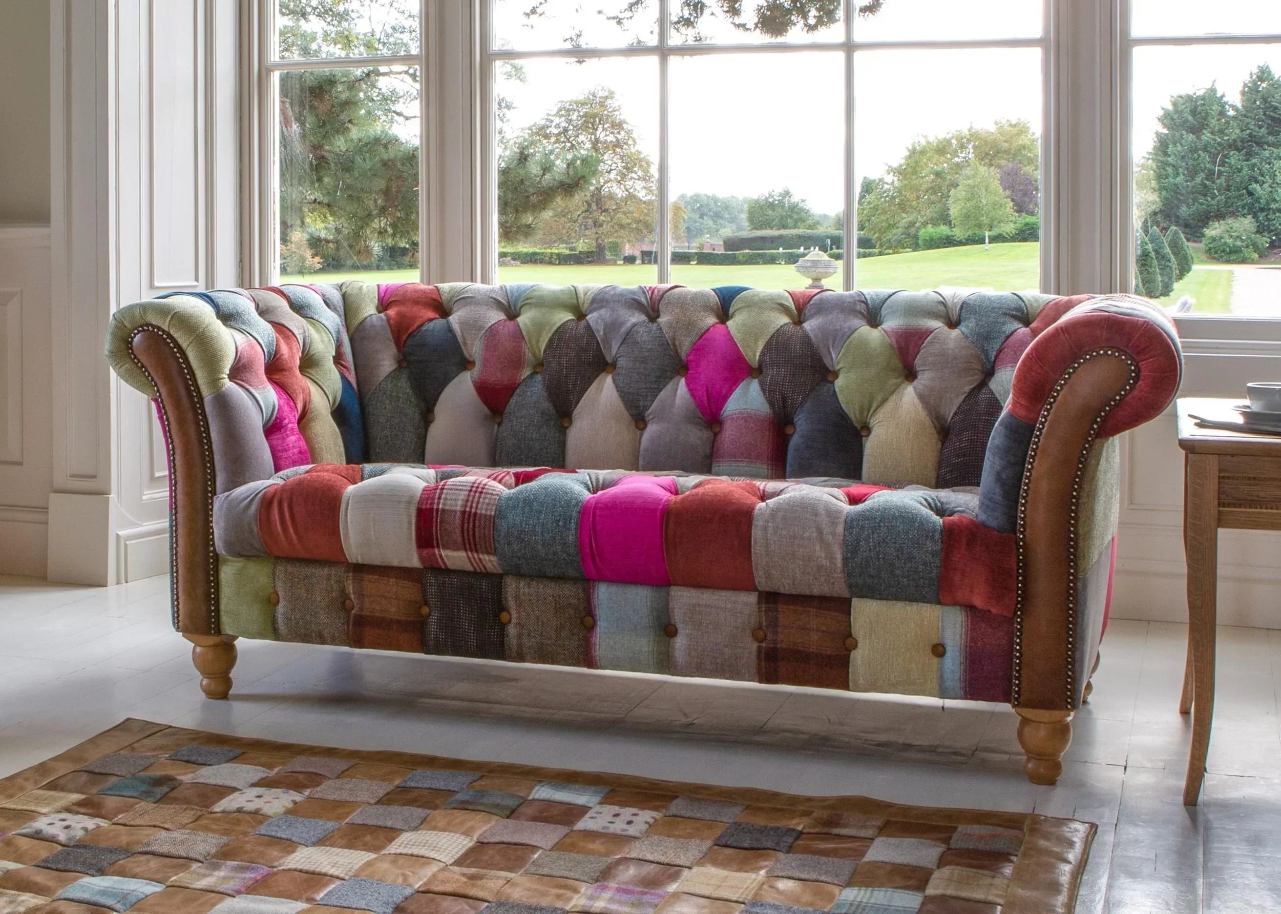 Patchwork fabric sofa with button detailing and wooden legs in a bright living room