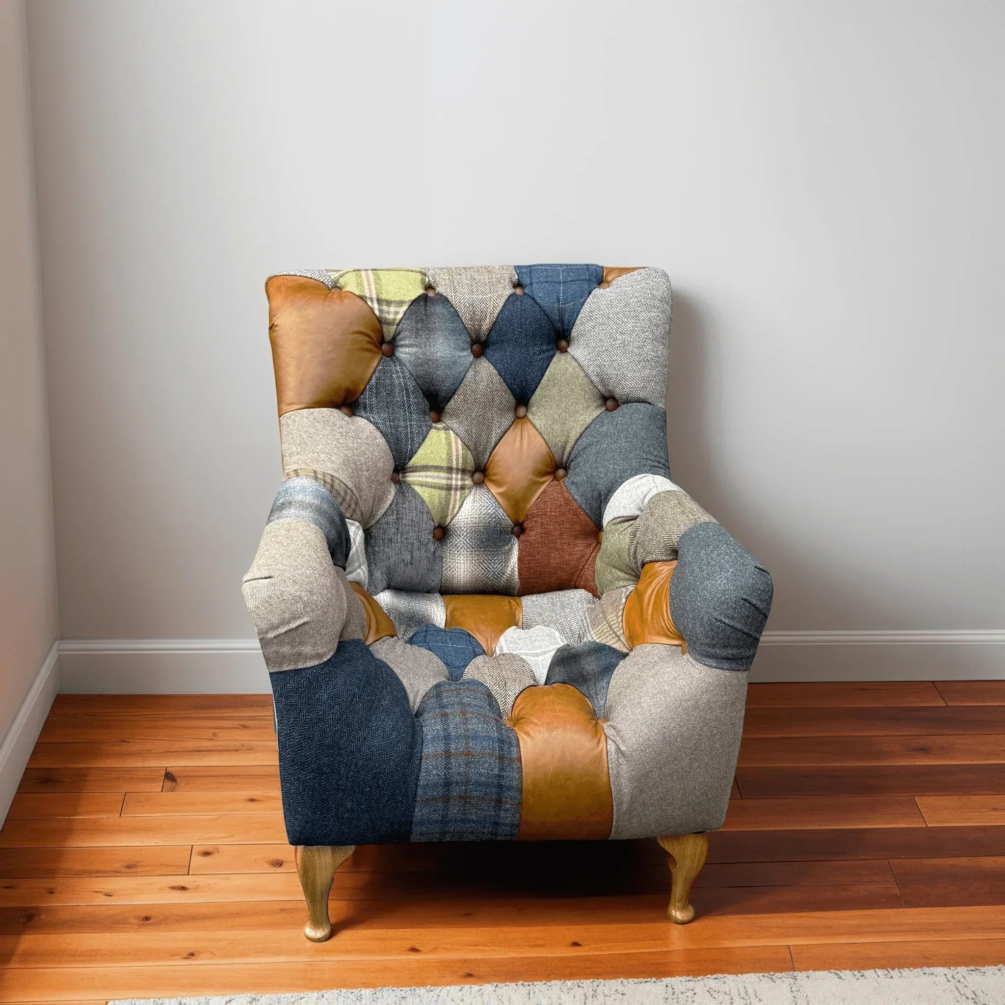 Patchwork armchair with tufted back, mixed fabric and leather upholstery, wooden floor