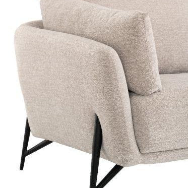 Beige fabric sofa arm detail with black metal legs and plush cushions
