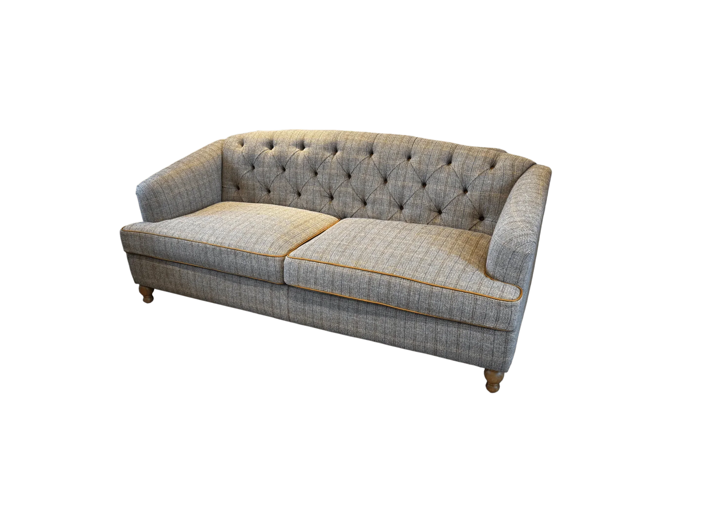 Grey fabric sofa with button-tufted back, wooden legs, and contrasting trim detail