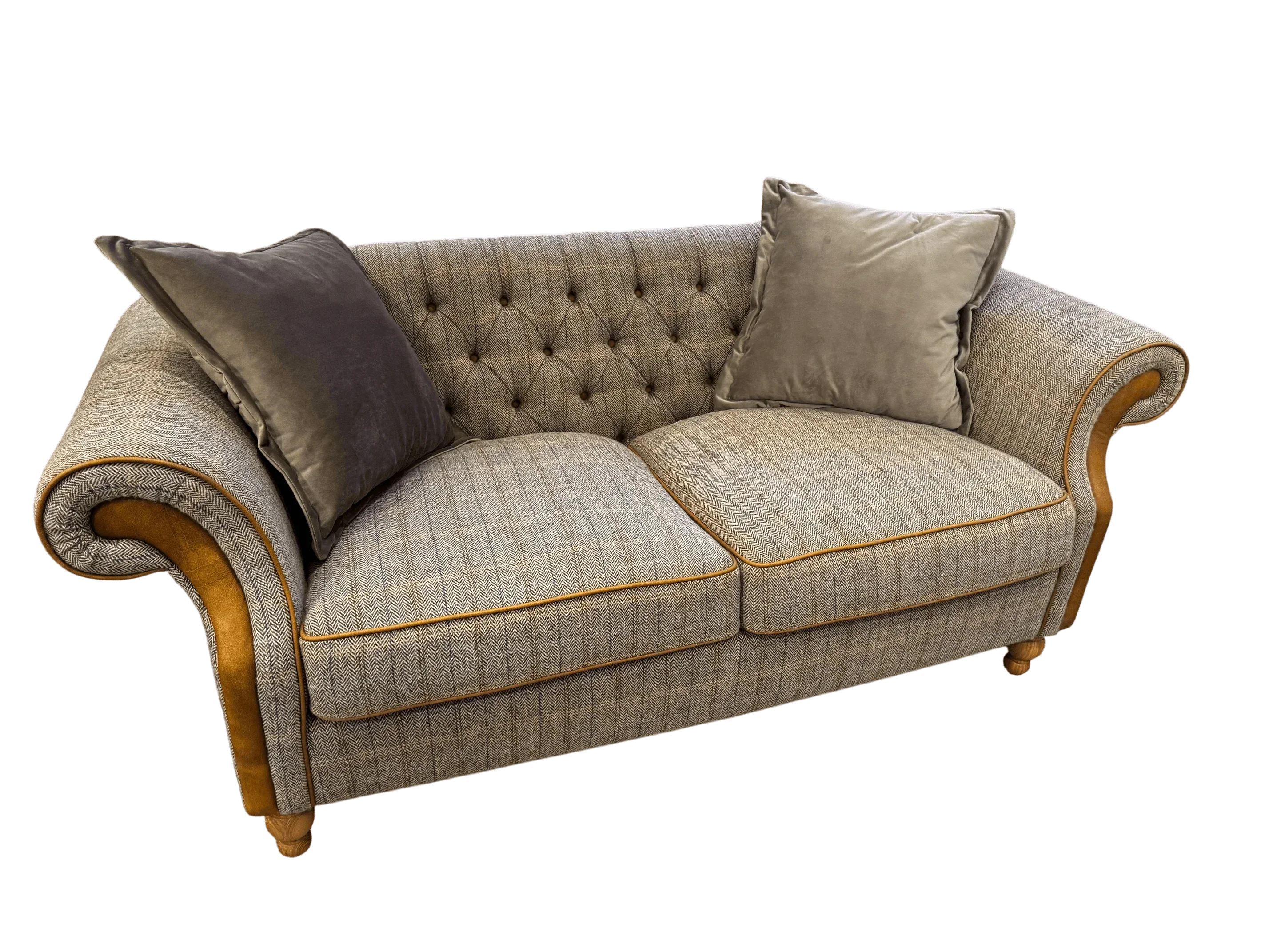 Grey fabric sofa with button-tufted back, mustard piping, rolled arms and two plush cushions