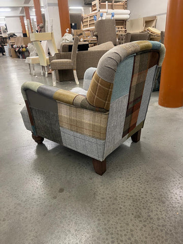 Patchwork armchair with wooden legs in furniture workshop setting