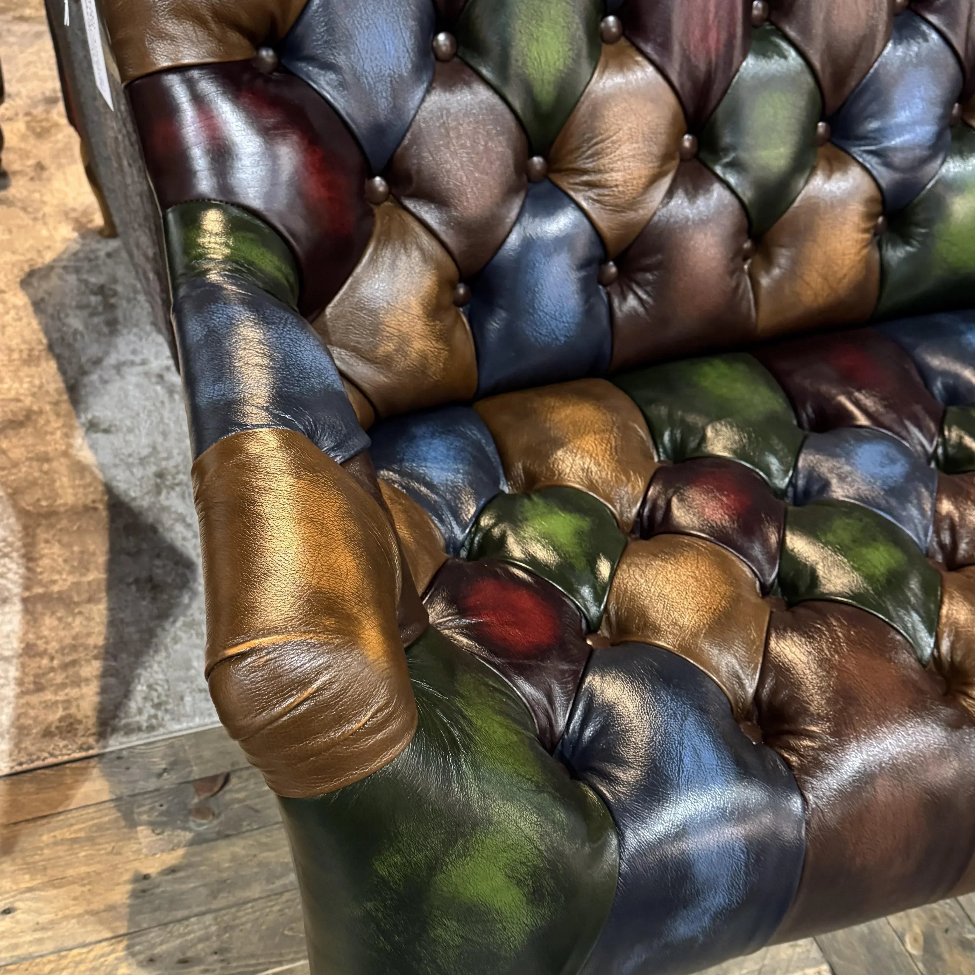 Tufted leather sofa with multicolour patchwork upholstery and wooden legs