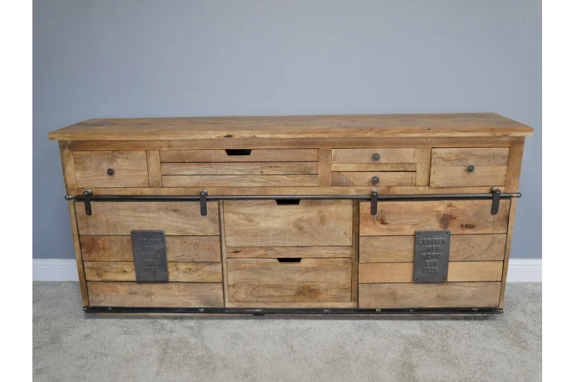 Rustic wooden sideboard with sliding barn doors and metal accents on grey carpet