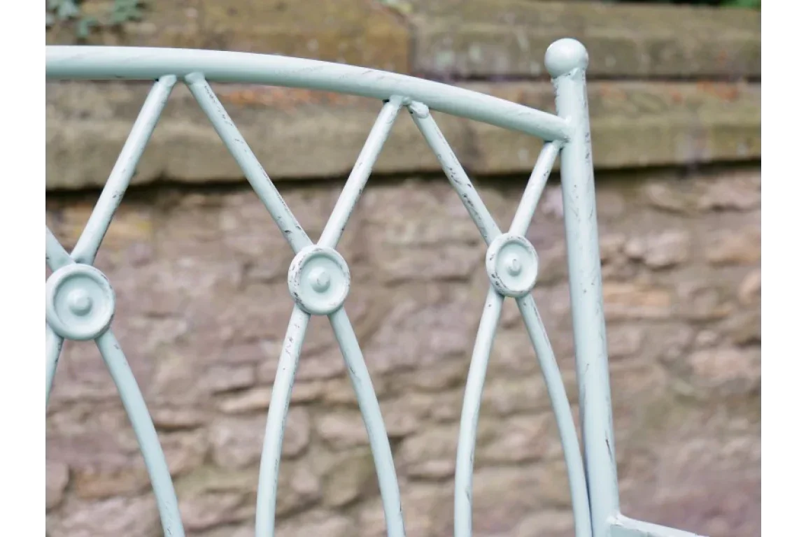 Close up of metal garden bench backrest with decorative circular and X-shaped details