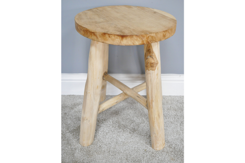 Round wooden stool with three legs and cross support, light natural wood finish, front angle on carpeted floor.