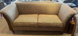 Fabric sofa with herringbone pattern, flared arms and wooden legs in showroom setting
