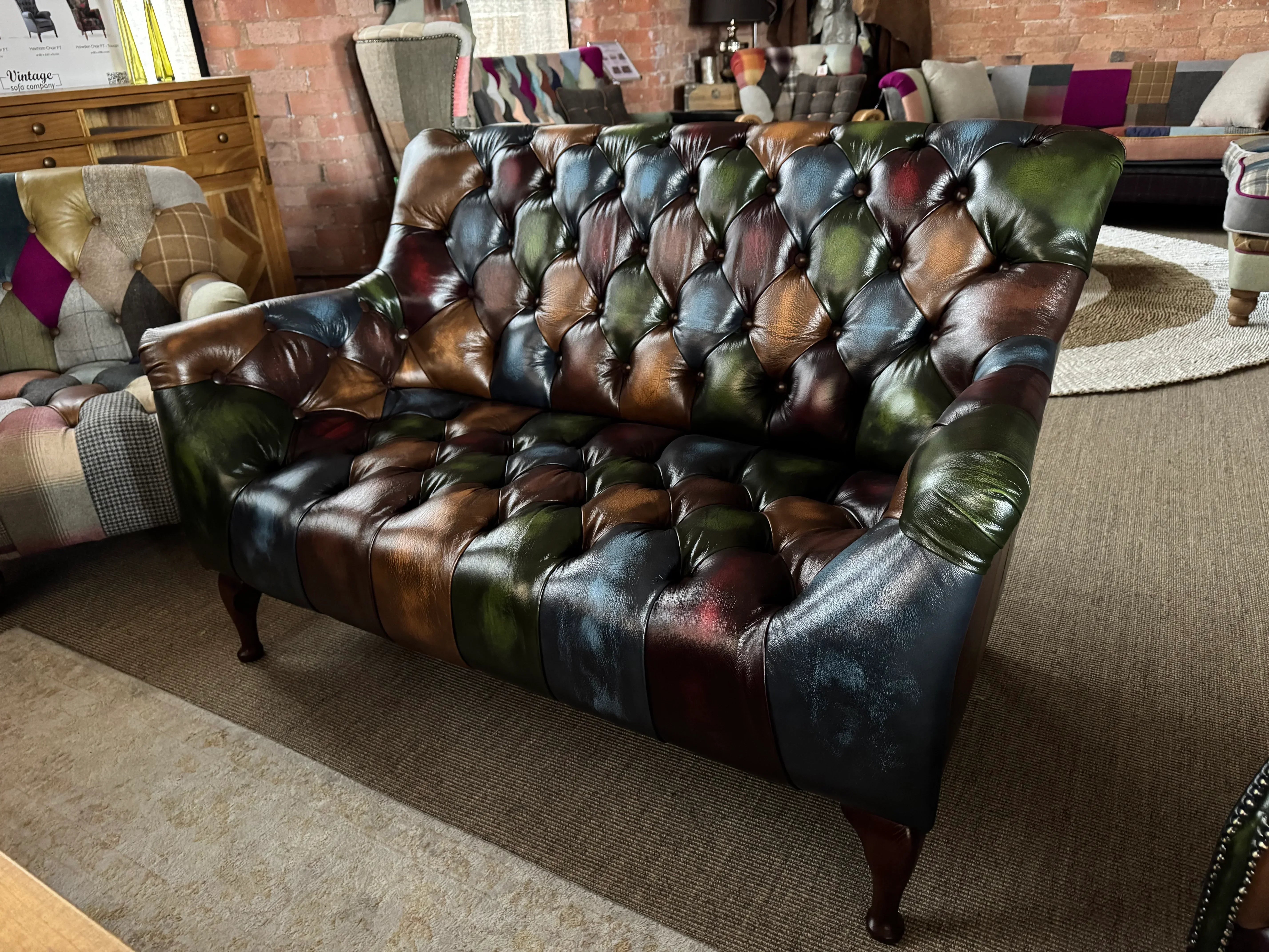 Chesterfield leather sofa with patchwork design and button tufting in living room setting