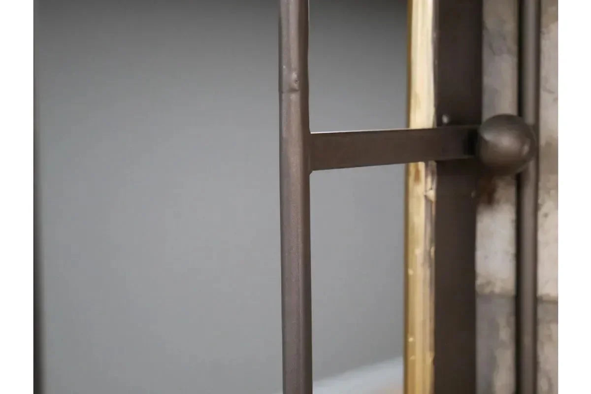 Black metal mirror frame with gold trim and round detail, close-up angle view