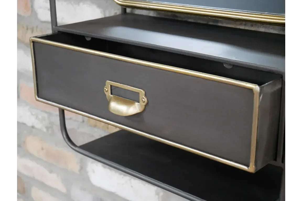 Black metal console table drawer with gold handle and trim, close-up view