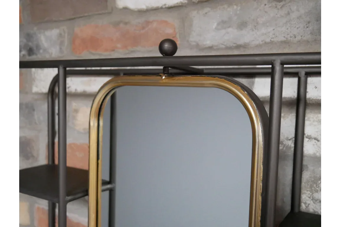 Metal and glass wall mirror with gold frame detail against brick background