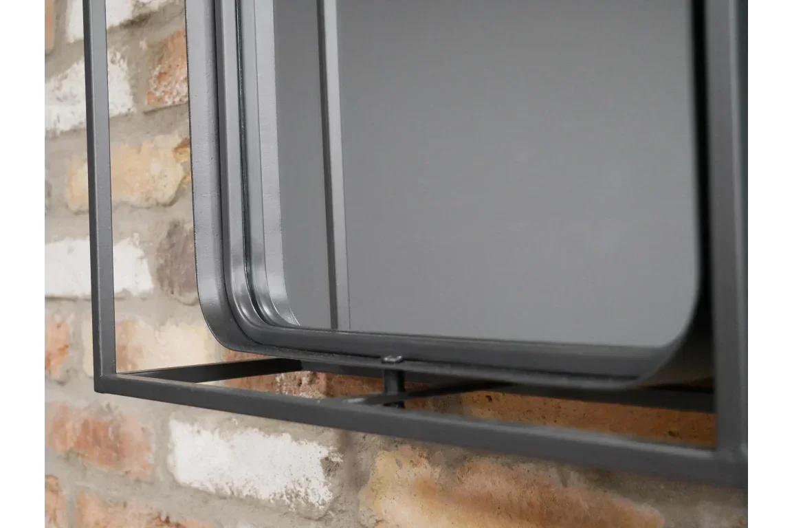 Black metal frame wall shelf close-up against exposed brick background