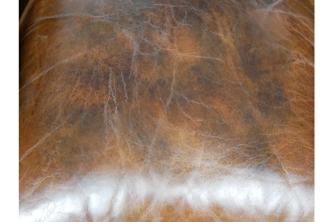 Close-up of brown leather sofa upholstery with natural texture and finish