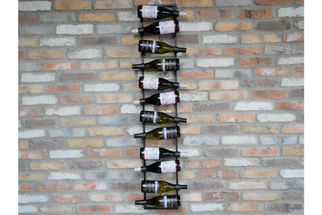 Black metal vertical wine bottle holder mounted on a multicolored brick wall, holding alternating bottles horizontally.