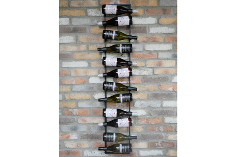 Vertical black metal wine bottle holder mounted on a multicolored brick wall with ten bottles displayed horizontally.