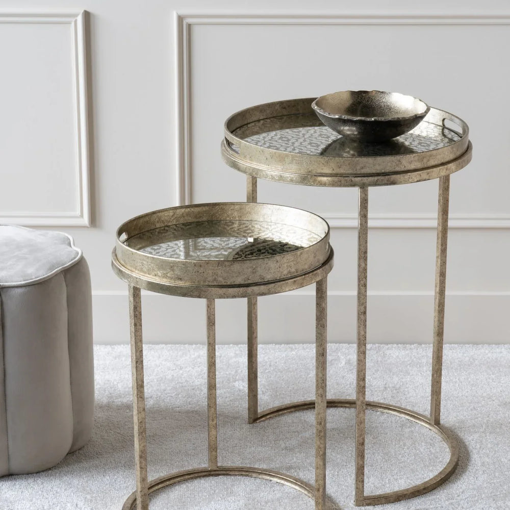Antique gold side tables with glass tops in a stylish living room setting.