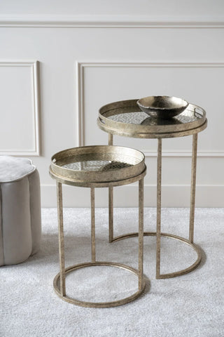 Antique gold side tables with glass tops in a stylish living room setting.