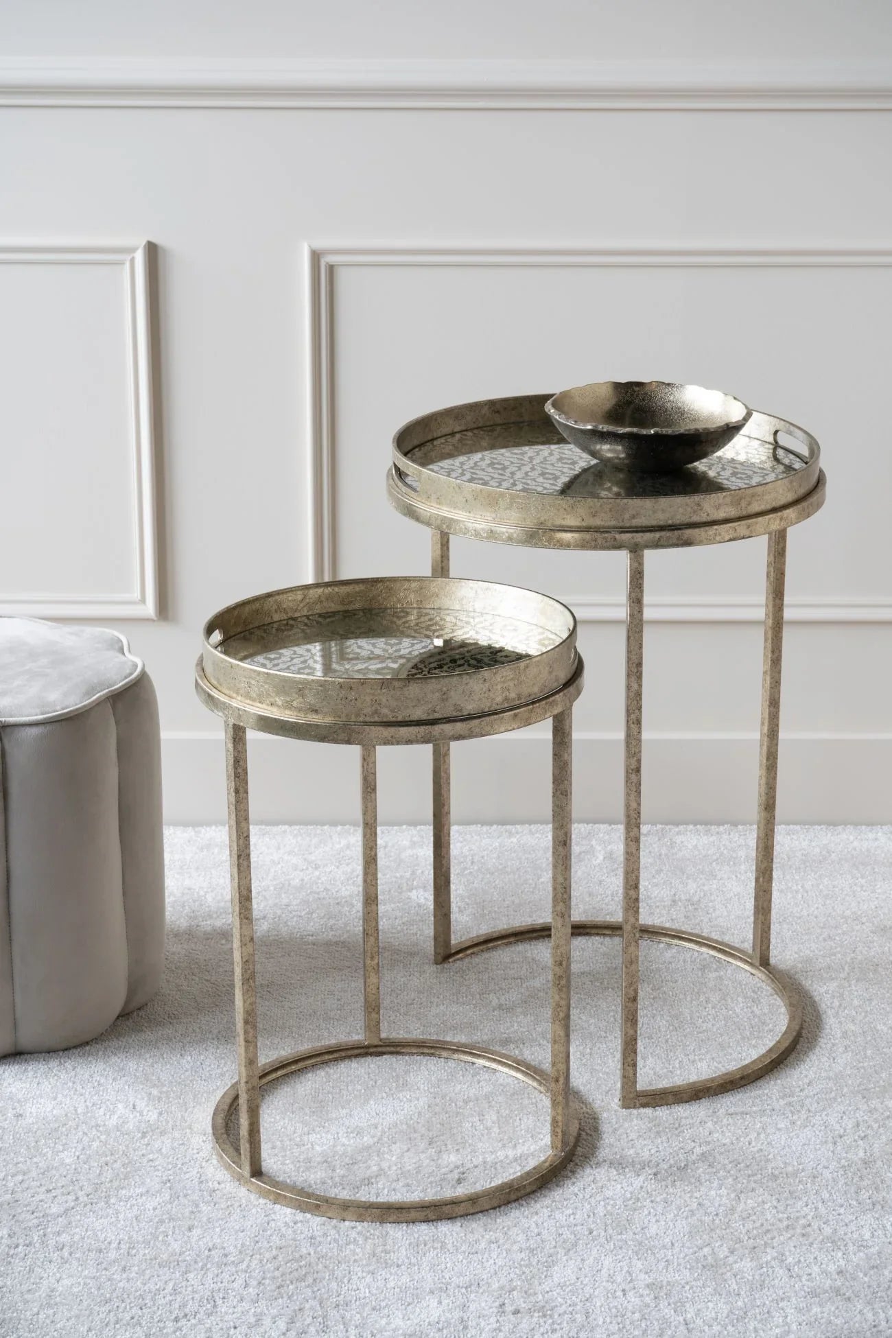 Antique gold side tables with glass tops in a stylish living room setting.